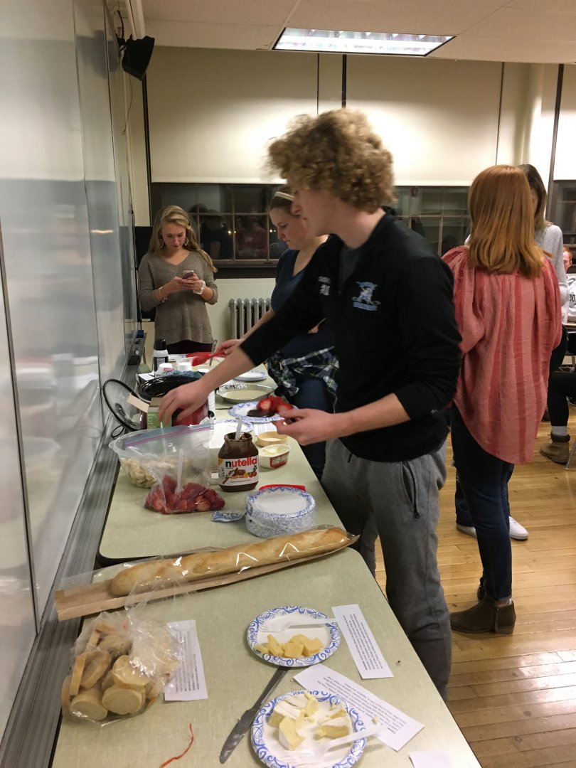 Student standing at food table.