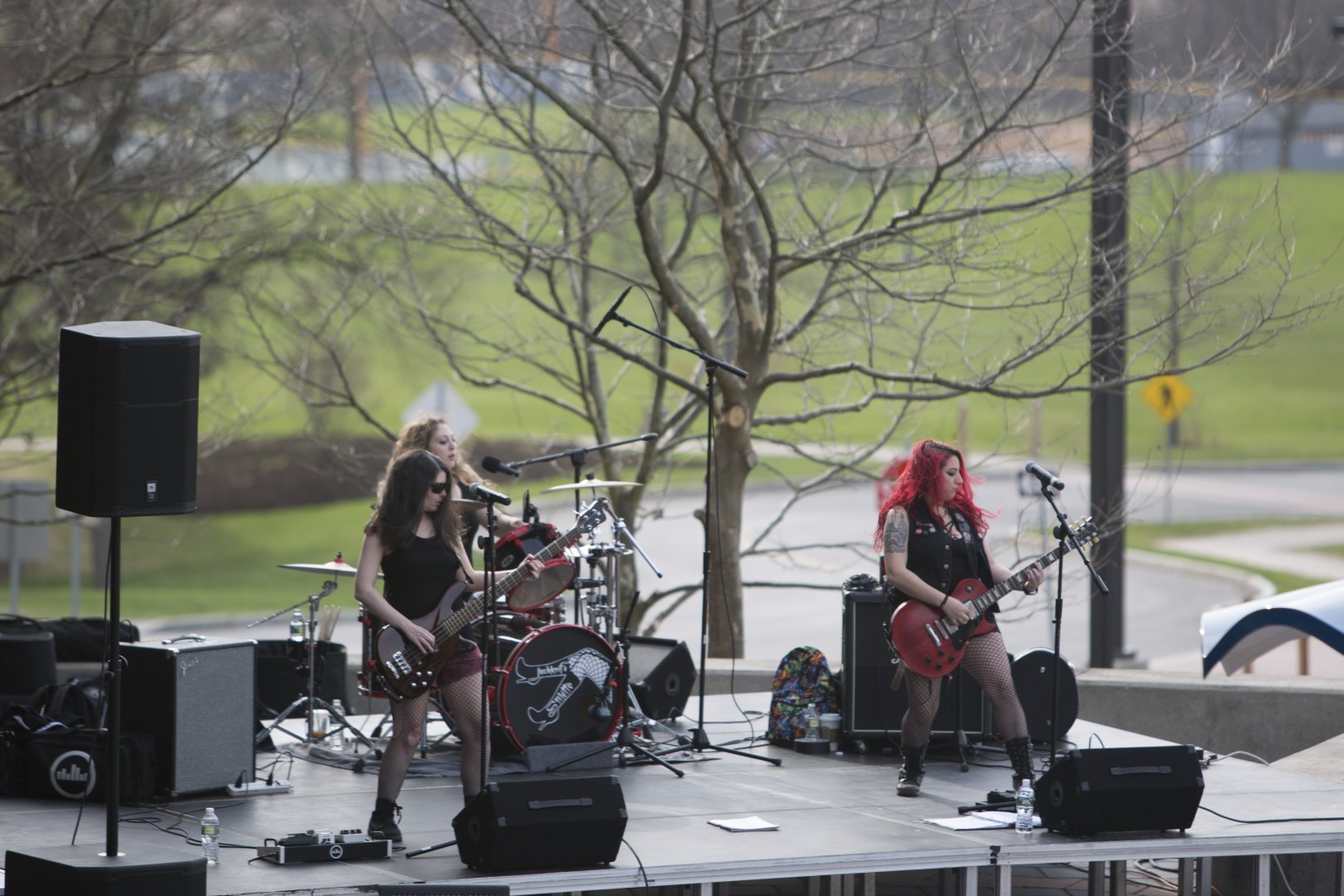 Jackknife Stiletto performing onstage at Genny Fest 2018. Three artists, two performing with guitars and one playing drums.