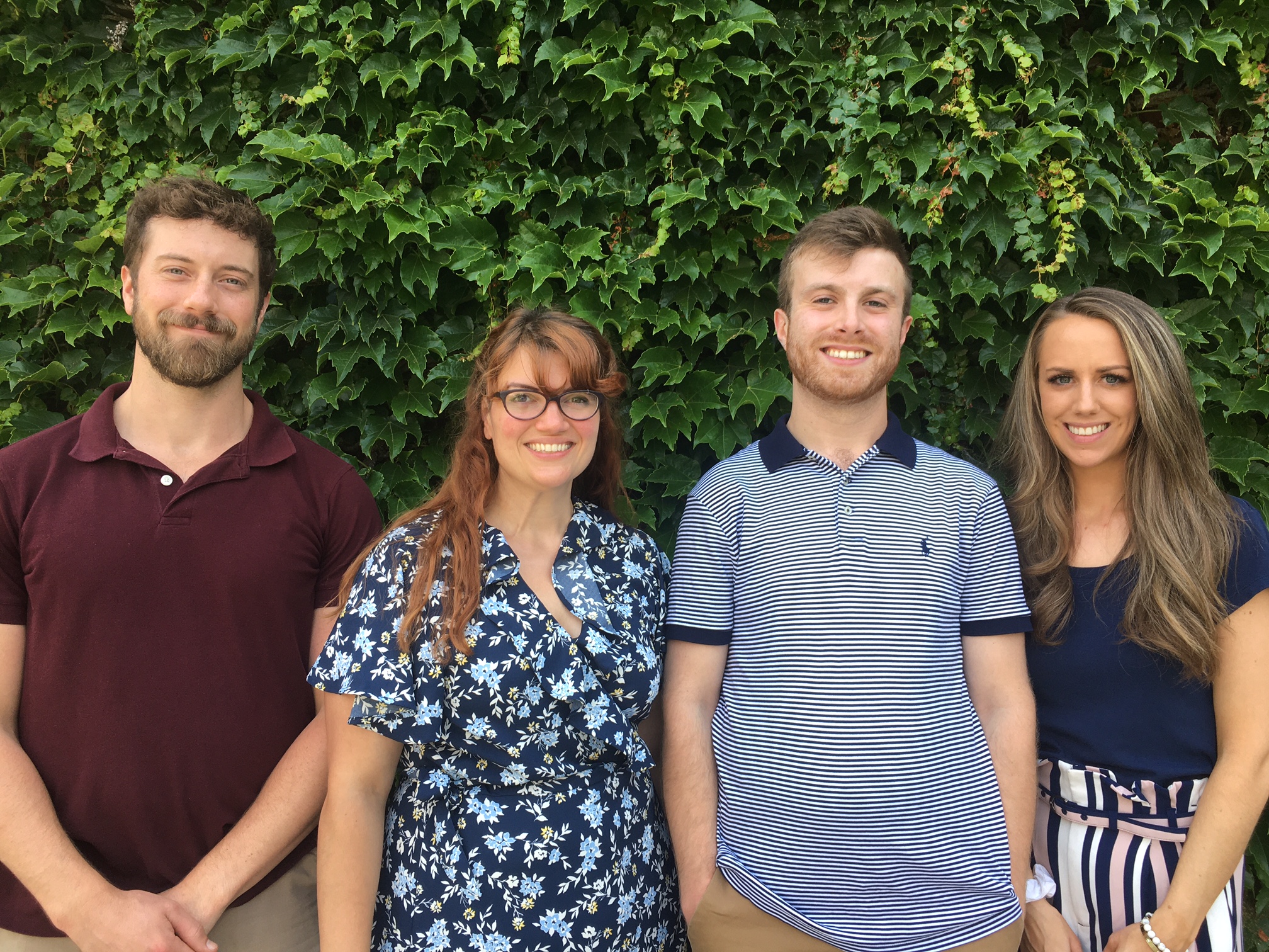 Four alumni stand with each other. 