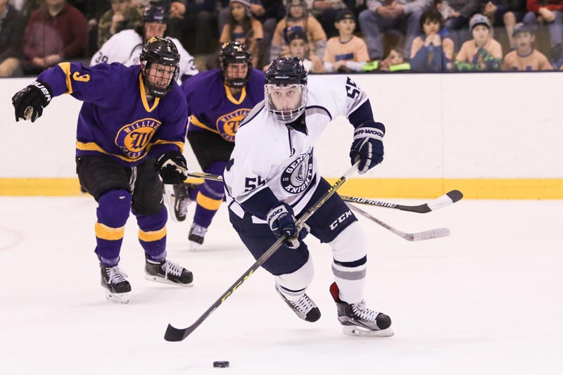A player for the SUNY Geneseo Ice Knights guards the puck during a game. A player for the SUNY Geneseo Ice Knights guards the puck during a game.