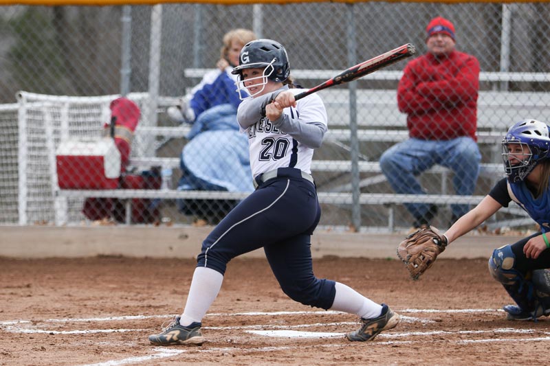 Woman swinging a baseball bat at home plate in front of the catcher. Woman swinging a baseball bat at home plate in front of the catcher.