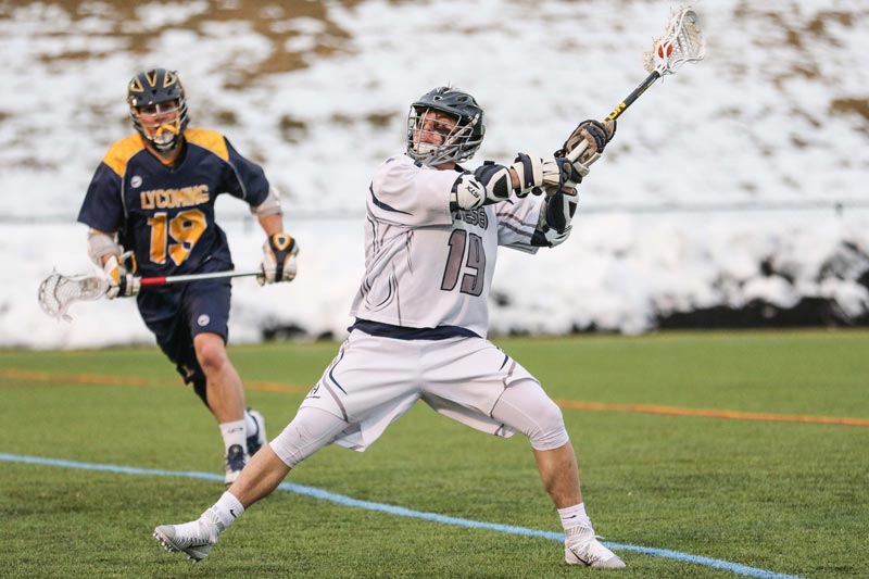 A SUNY Geneseo men's lacrosse player catching a ball A SUNY Geneseo men's lacrosse player catching a ball