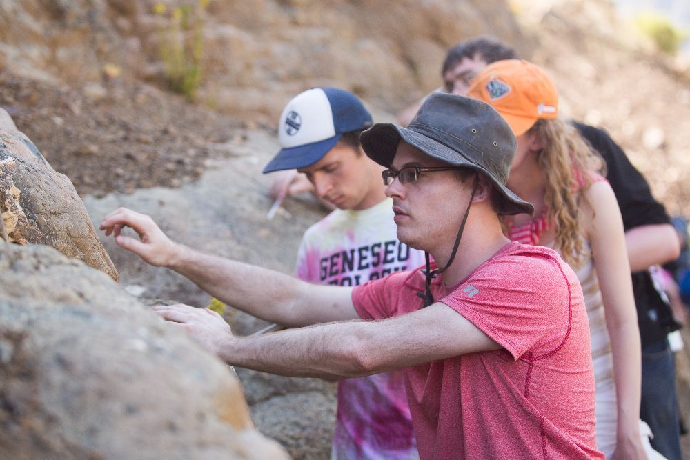 Students examoine a large rock.