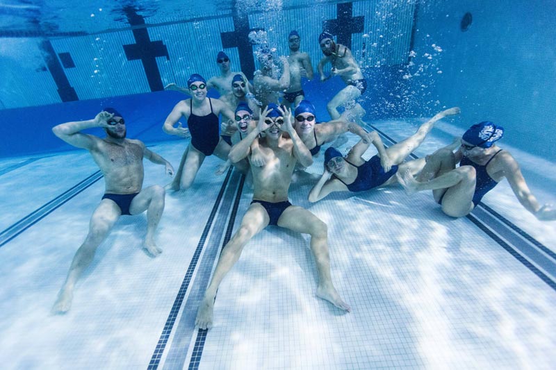 The Blue Wave swim team at SUNY Geneseo, posing underwater. The Blue Wave swim team at SUNY Geneseo, posing underwater.