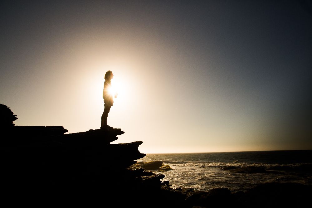 A sillhouette on a rocky shore.