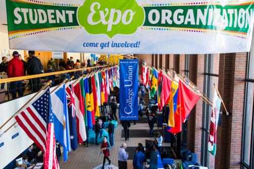 Image of SUNY Geneseo with many flags from different countries in the background.