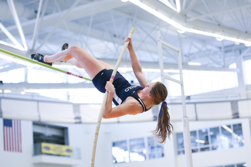 A SUNY Geneseo pole vaulter vaults over the bar. A SUNY Geneseo pole vaulter vaults over the bar.