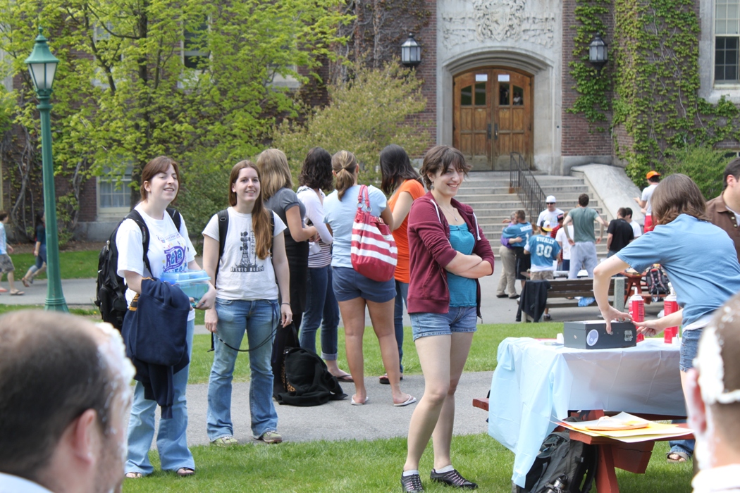 Pi in the face for autism event: student standing near table