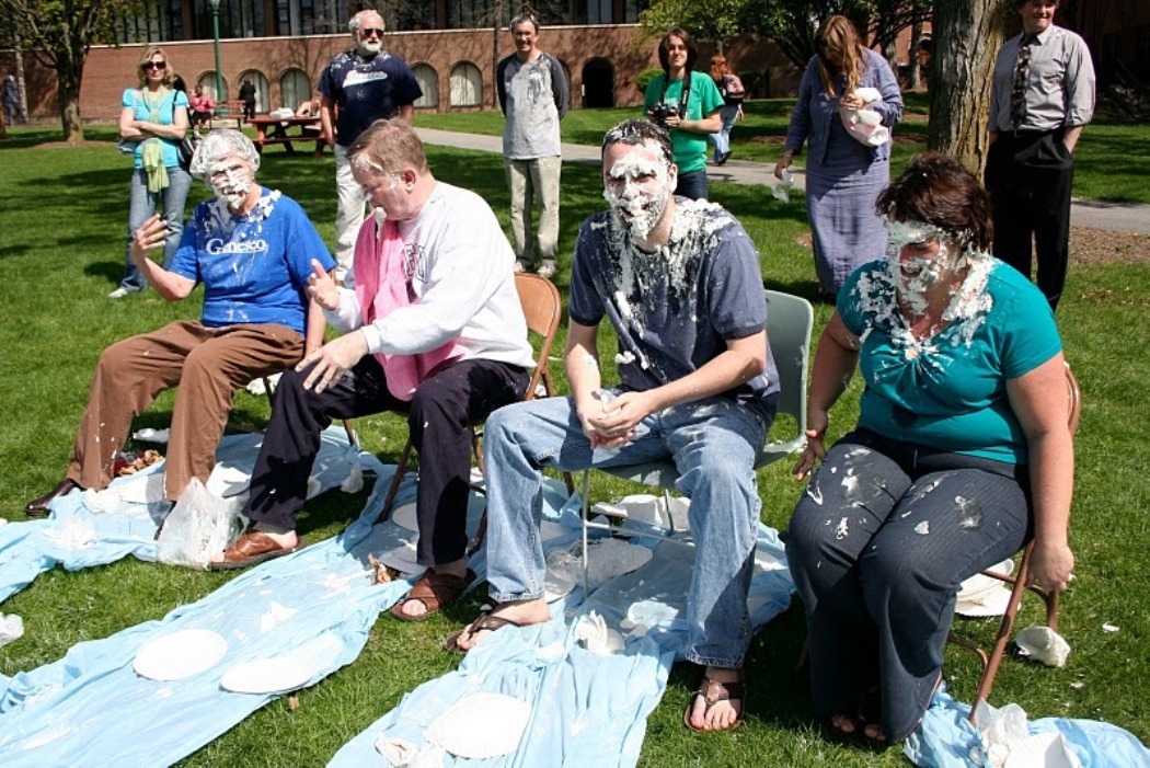 Pi in the face for autism event: Female student with pie in hand ready through