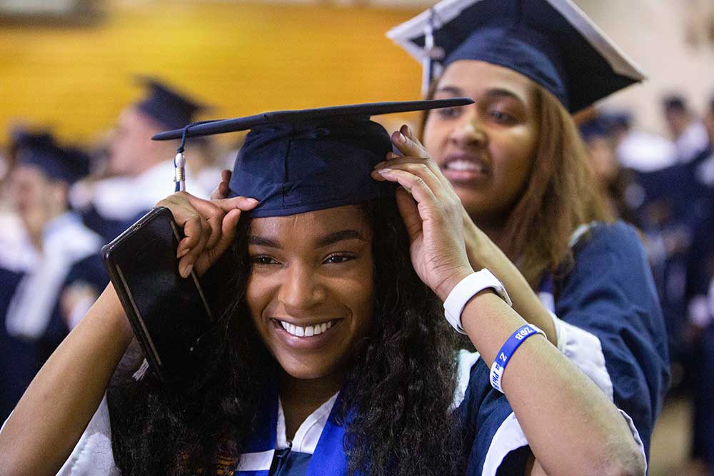 students fixing grad cap