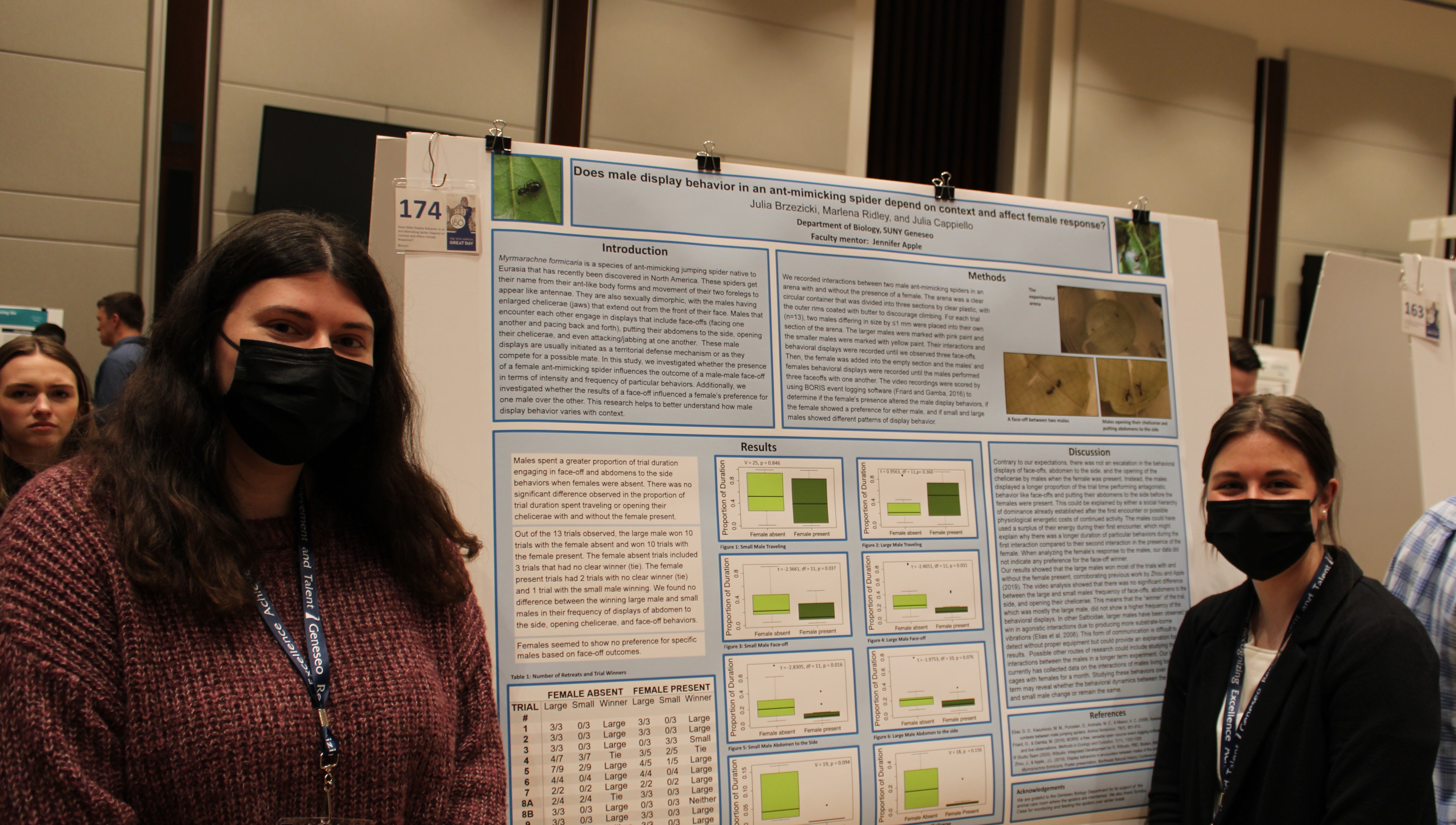 great Two students standing beside a posterboard on spider behavior.