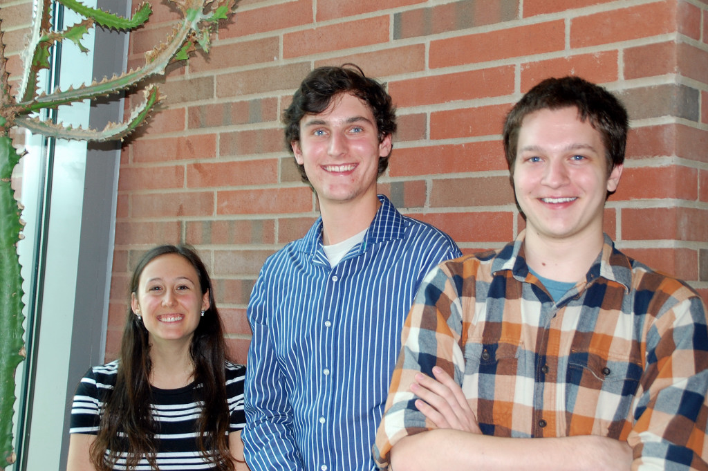 Three students standing together and smiling Three students standing together and smiling