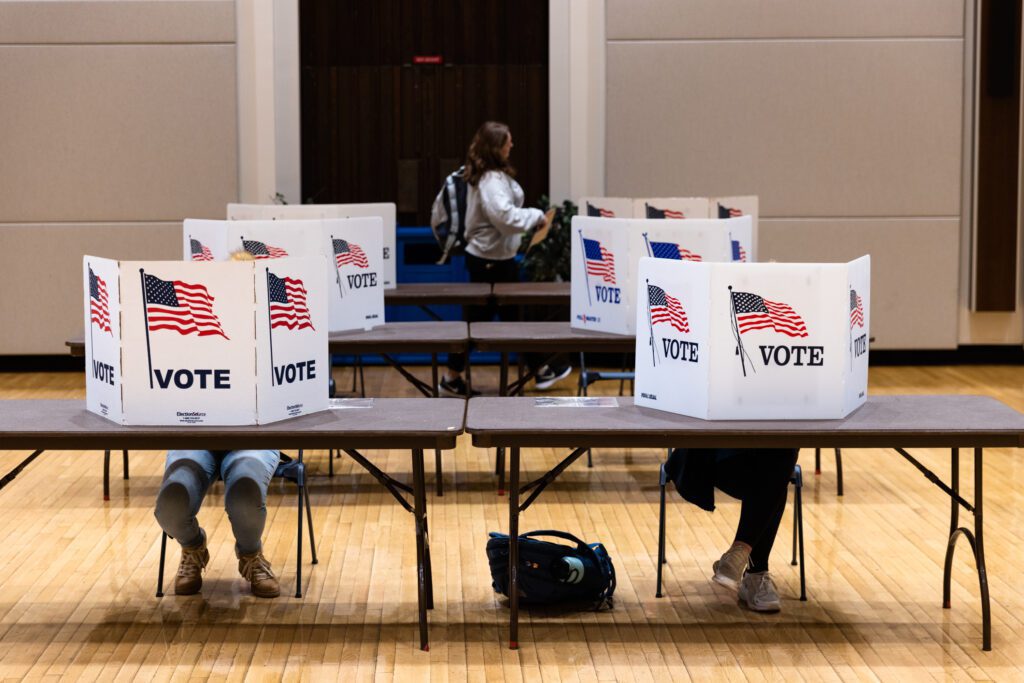 Students fill out ballots behind the privacy screens
