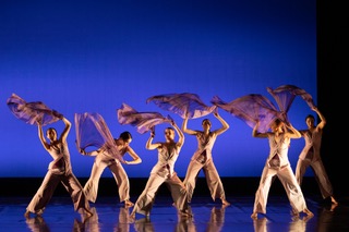 Members of the Geneseo Dance Ensemble perform against a blue background