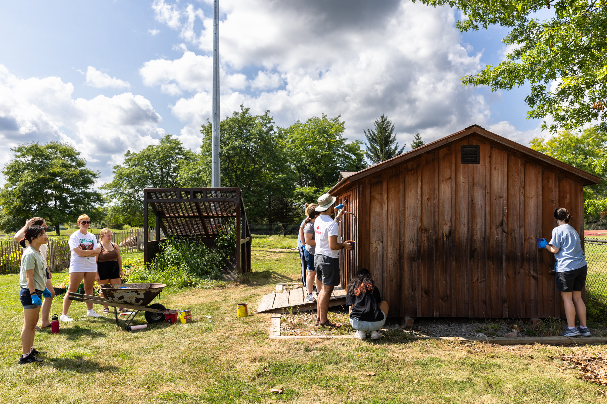 Student volunteers helping to maintain an outdoor shed