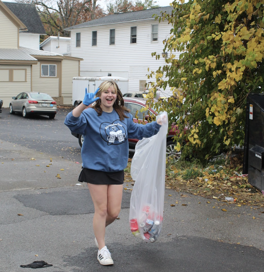 Student holding a plastic bag of litter.