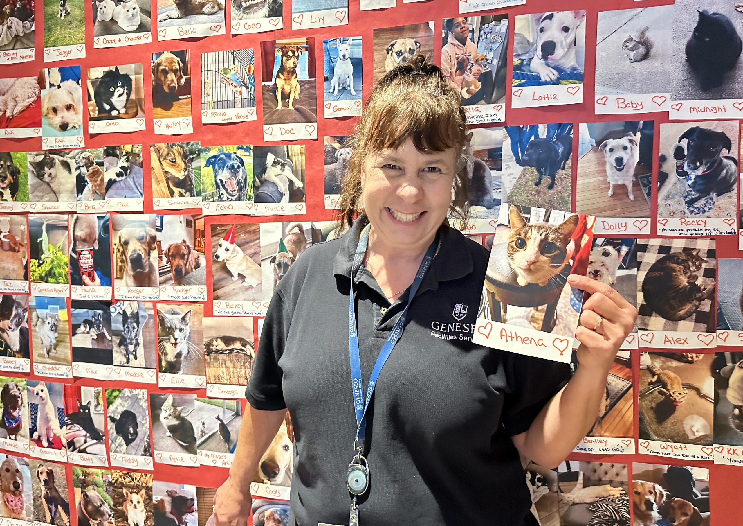 Ava Pascalar holds a photo of a cat, Athena, in front of the pet wall in the residence hall.