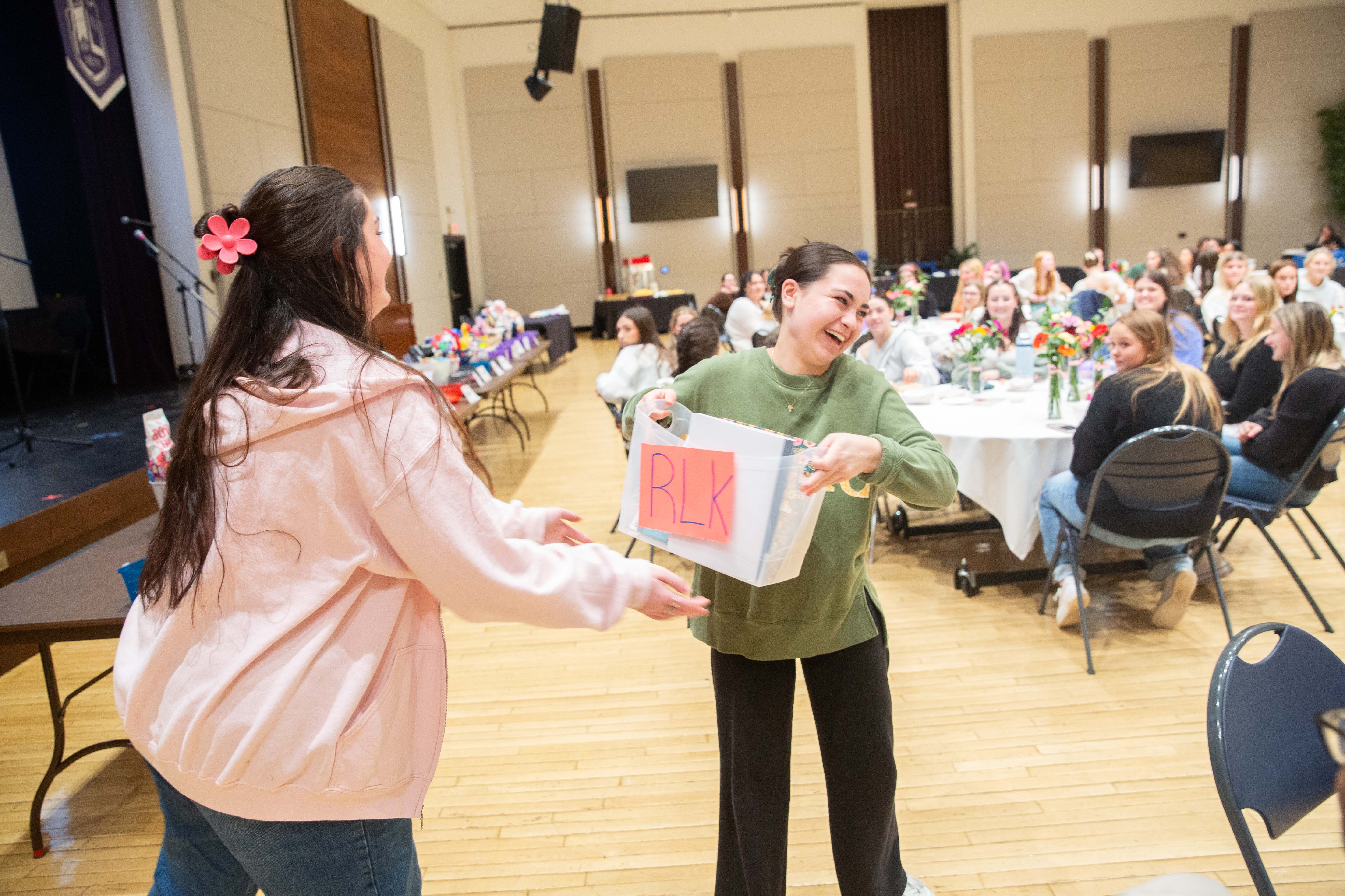 Two students holding a basket labeled RLK.