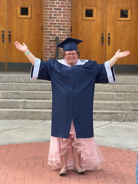 Graduate smiling and standing in front of Wadsworth Auditorium