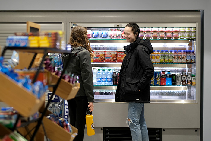 Two students browsing the beverage cooler at Jacku0026#039;s in the Red Jacket Dining Complex.