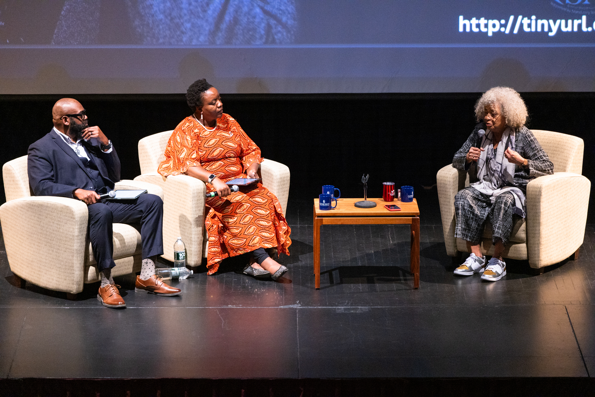 Panel of three people having a discussion on stage