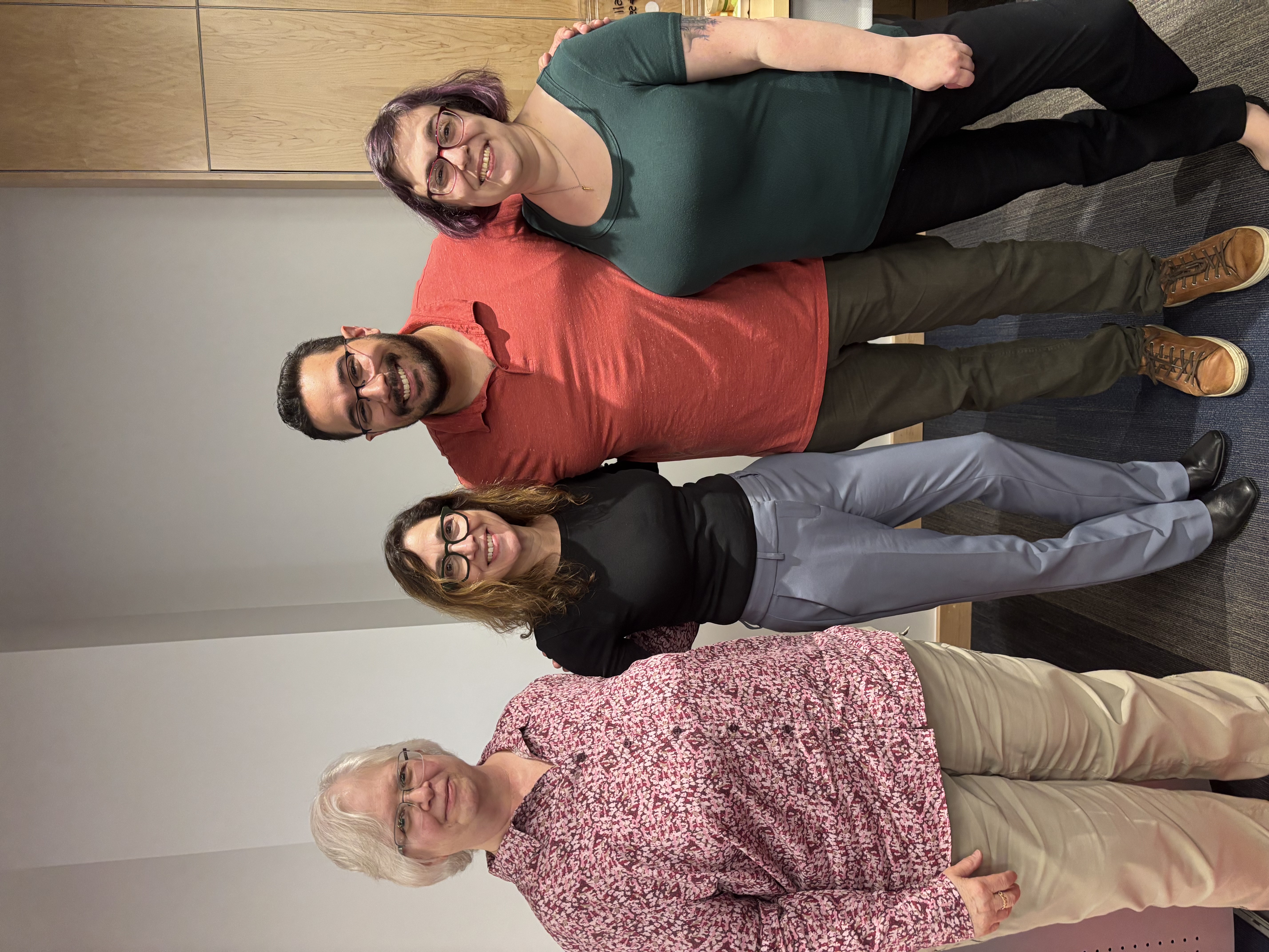 Four Sociology professors smiling and posing for a group photo indoors.