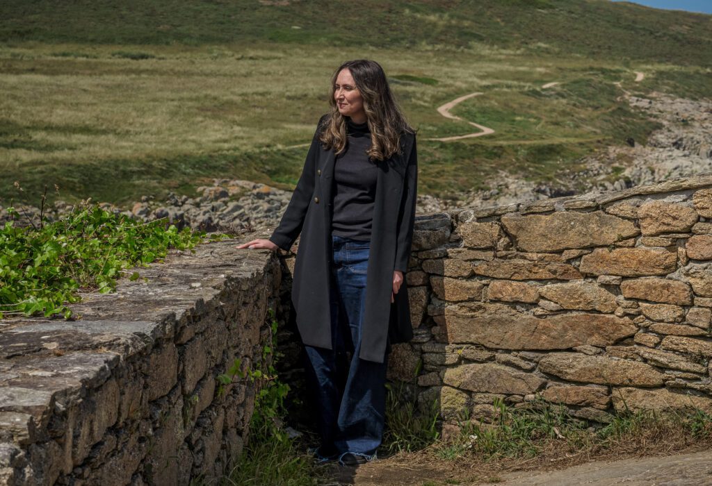 Meredith Cannella '09 stands in the Spanish countryside next to a stone wall.