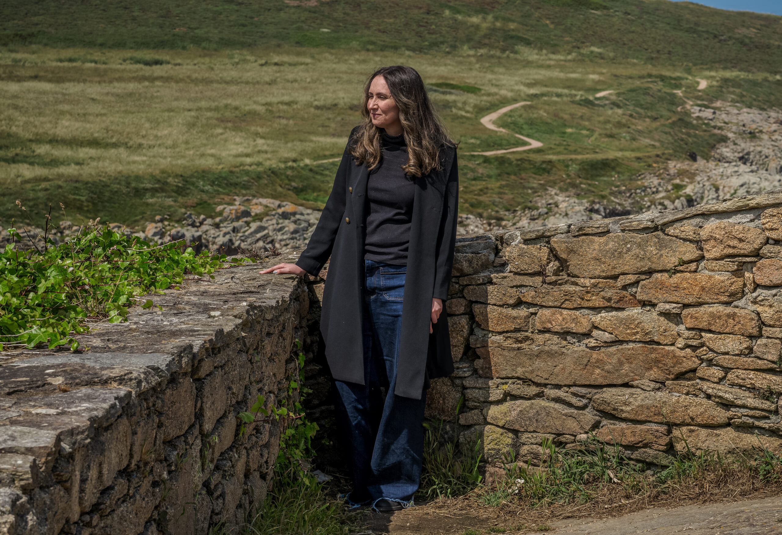 Meredith Cannella '09 stands in the Spanish countryside next to a stone wall.