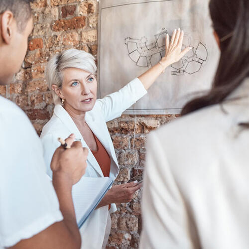 woman pointing at architectural drawing