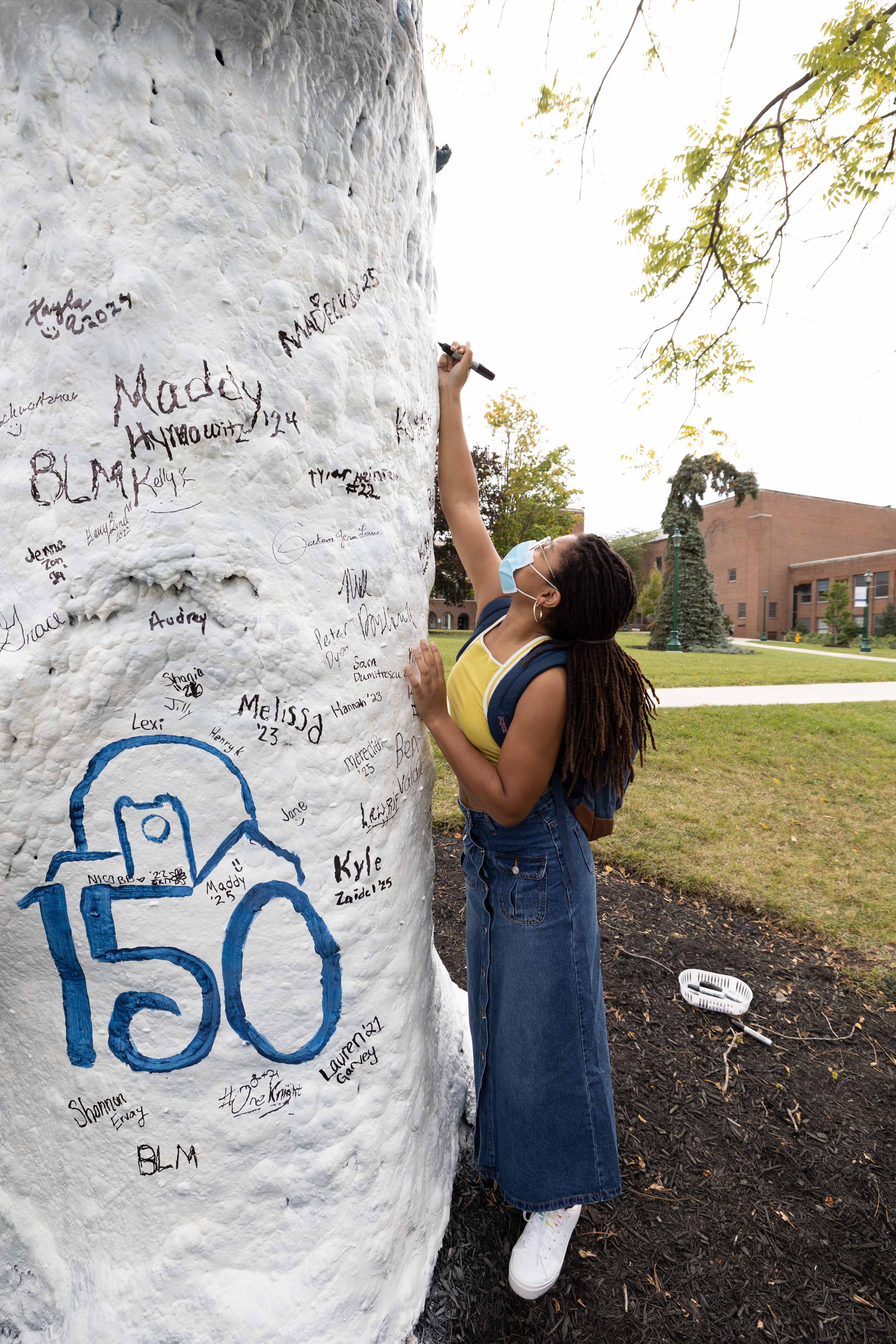 a student signs the tree