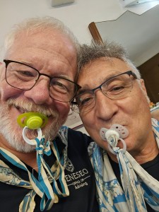 Wes Kennison '79 and Fabrizio Bindi suck on pacifiers. The pacifier is a symbol of victory in the Palio horse race. A victory means your life begins again.