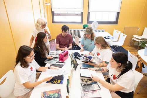 Students working around a table on literary magazine