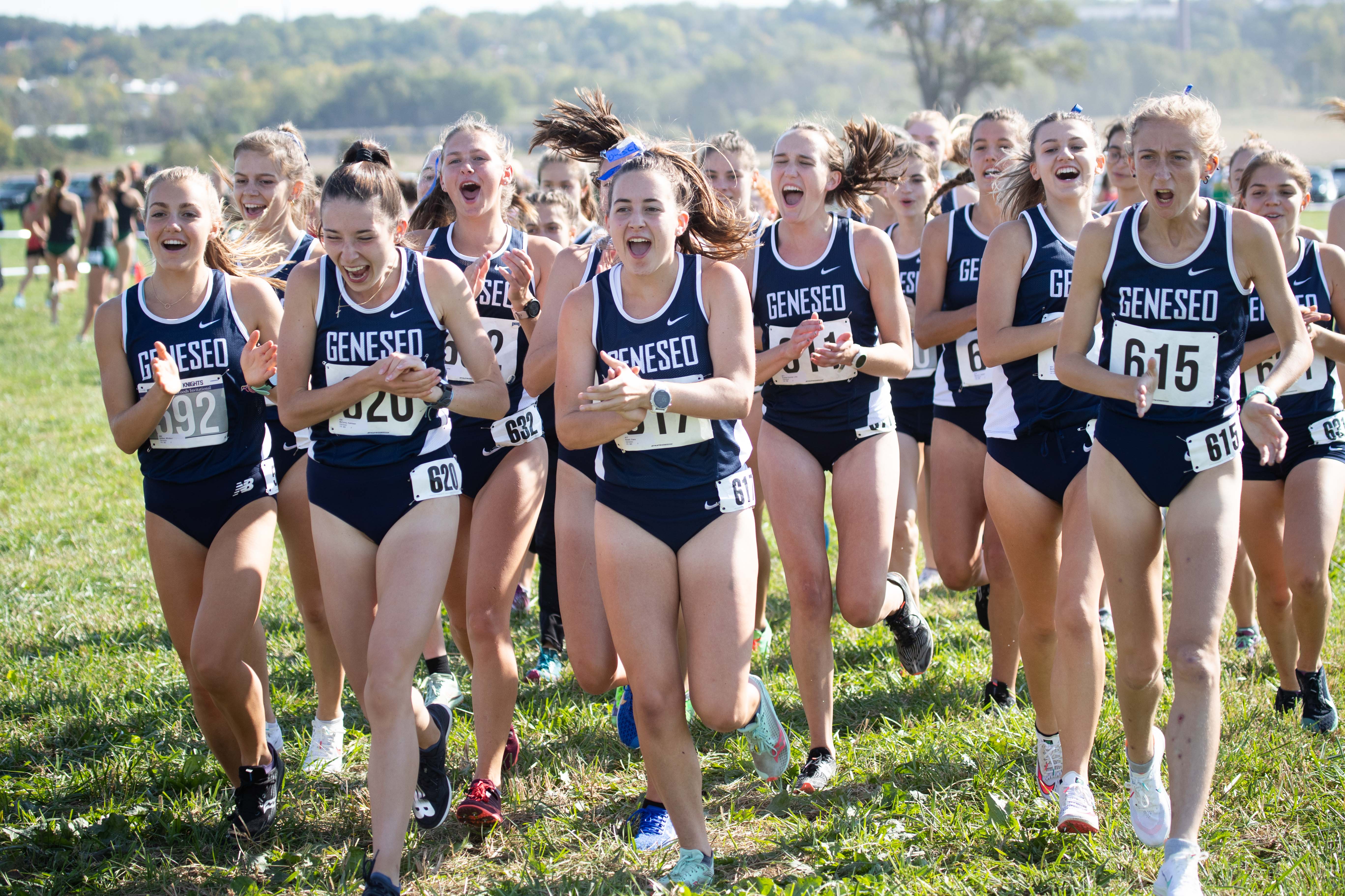Women's cross-country teammates cheer during a competition.