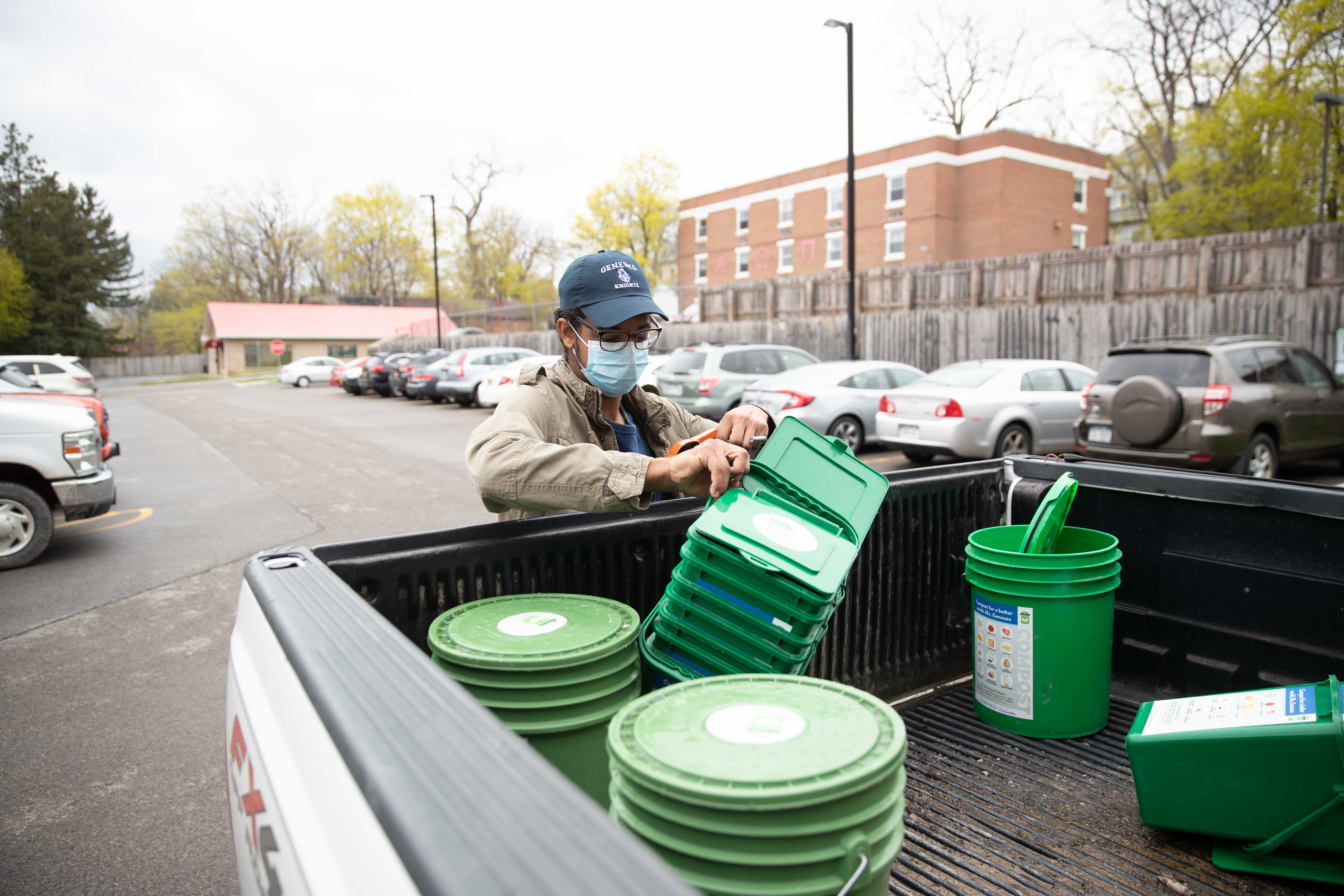 Yaro Bautista'23 stacks compost buckets in a truck.