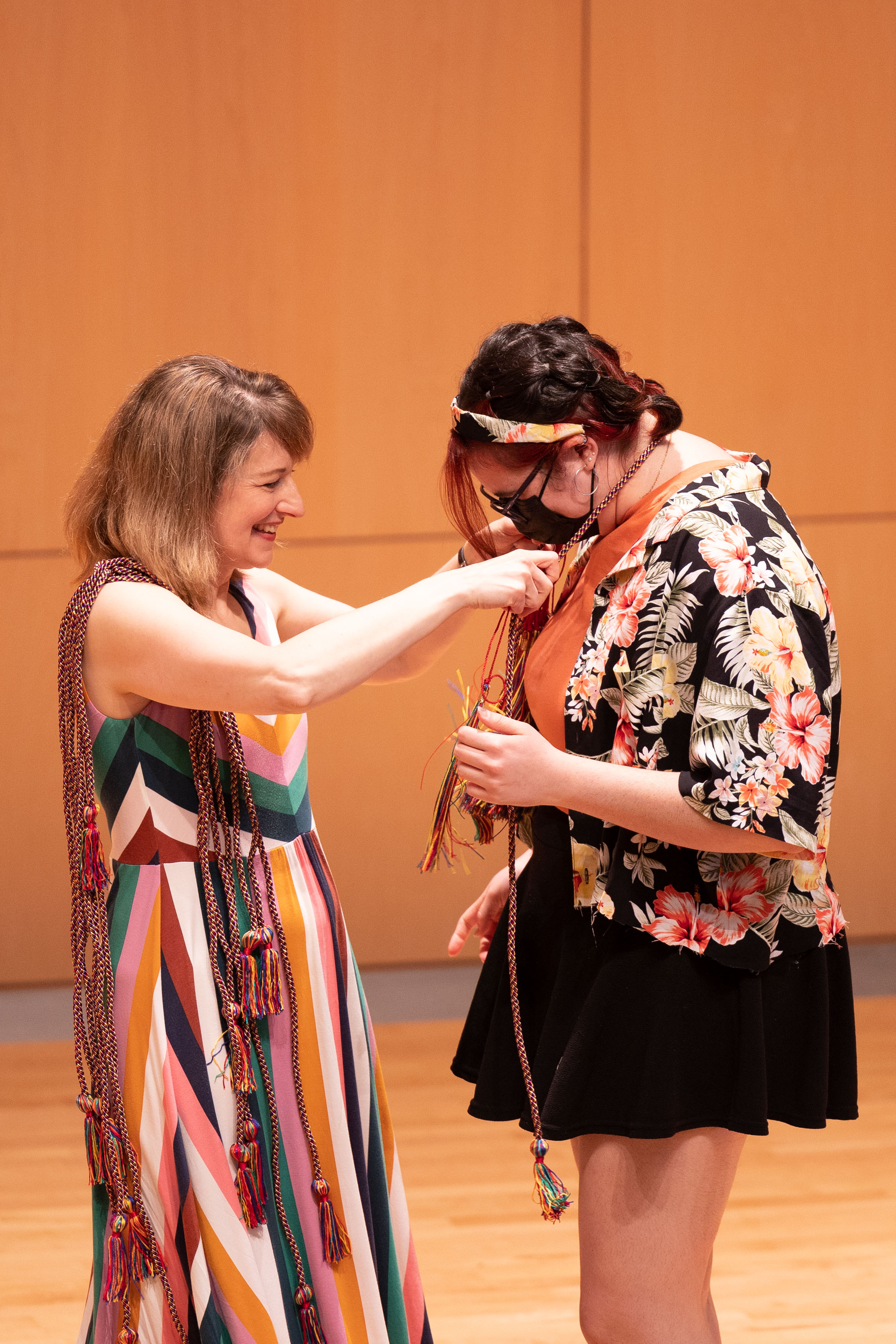 Department of English Chair and Associate Professor Alice Rutkowski hangs a celebratory sash on Emma Celt'22