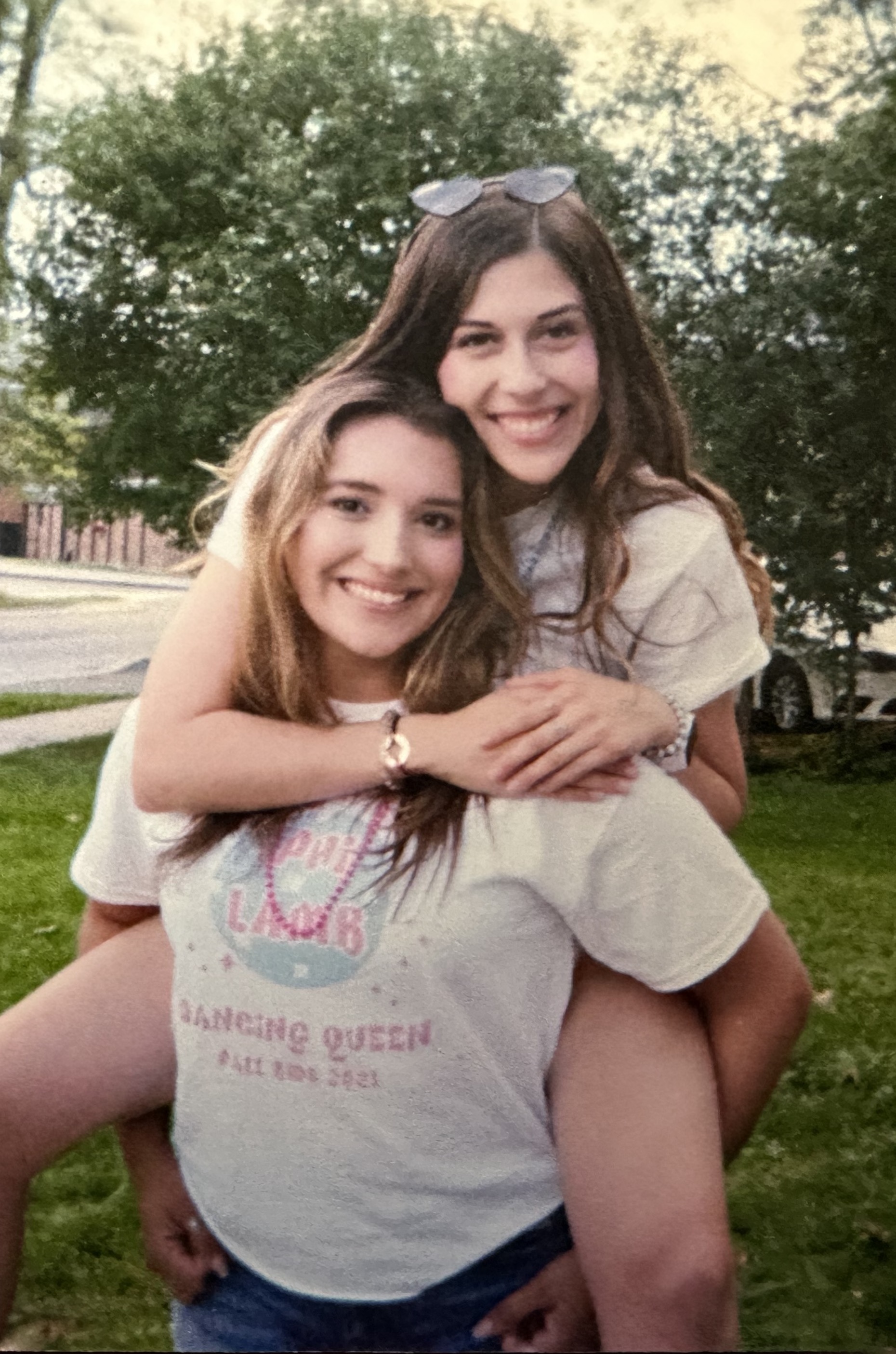 A photo of Natalie on the back of someone, getting a piggy back ride.