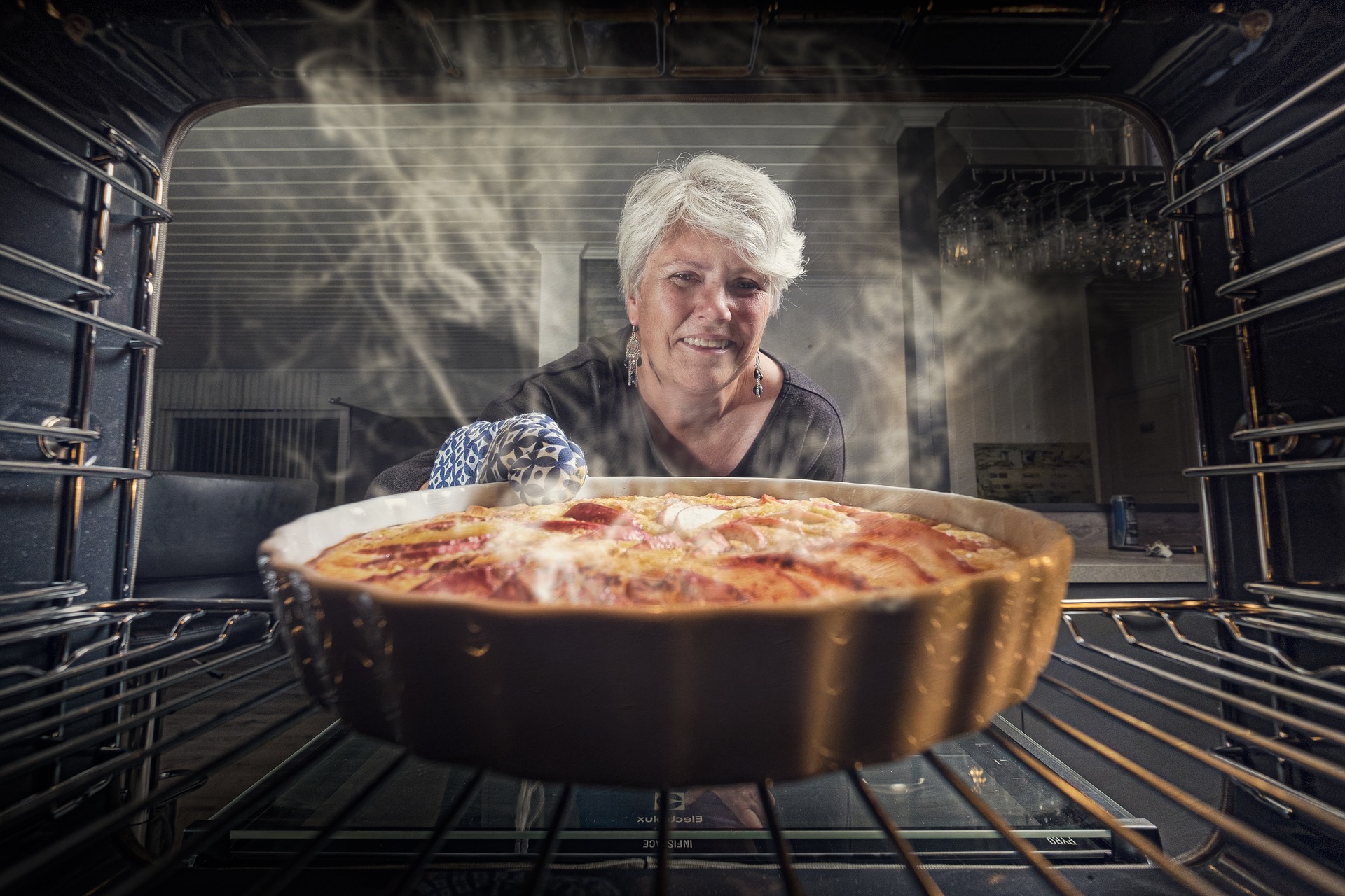 Woman takes a pie out of the oven