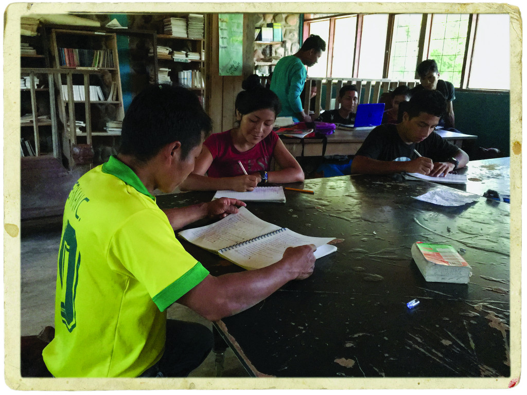 Students at a table with notebooks studying.