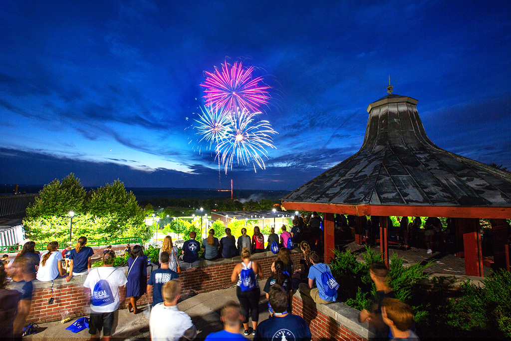 Students watch fireworks from standing at the gazebo