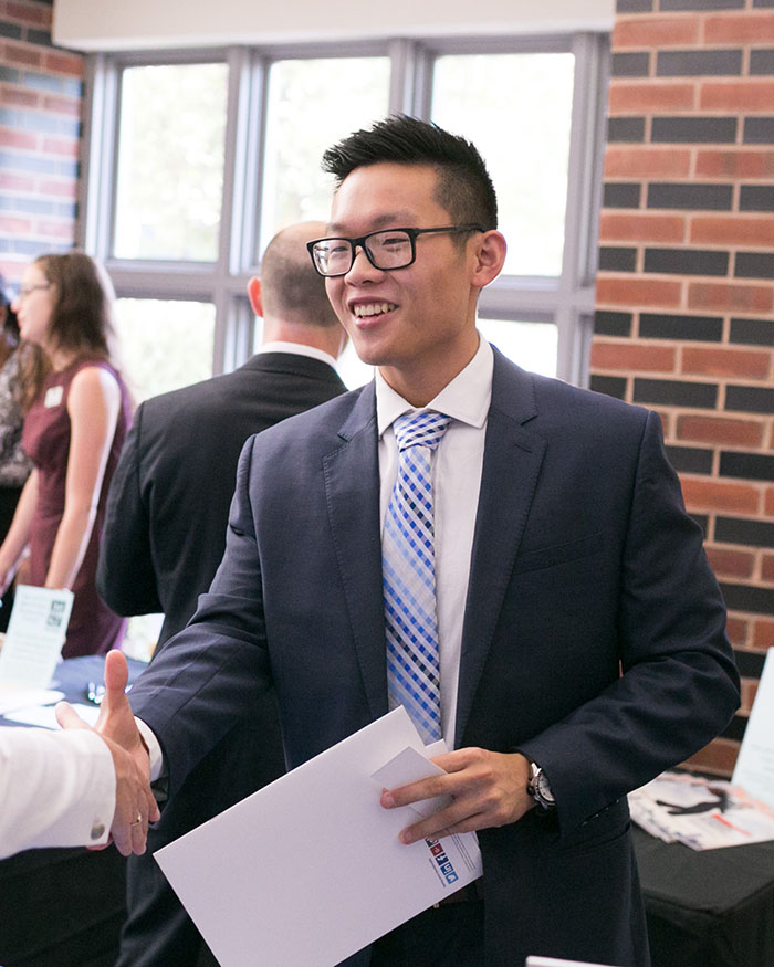 Student in a suit shaking hands