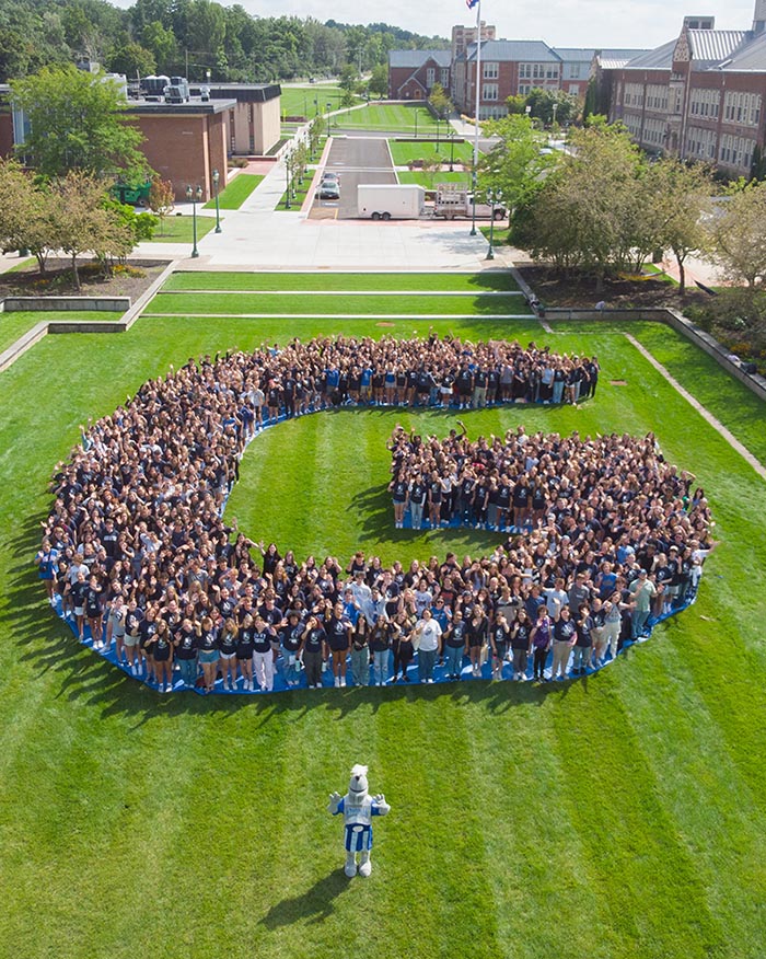 Students forming the letter "G" on the College Green