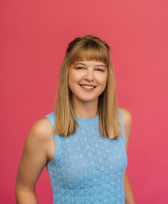 image of Kaelynn Partlow. There is a pink background. She has shoulder length blonde hair and is wearing a light blue tank top