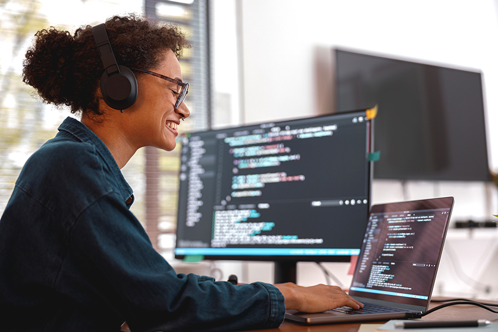 A student working at a computer with coding on screen