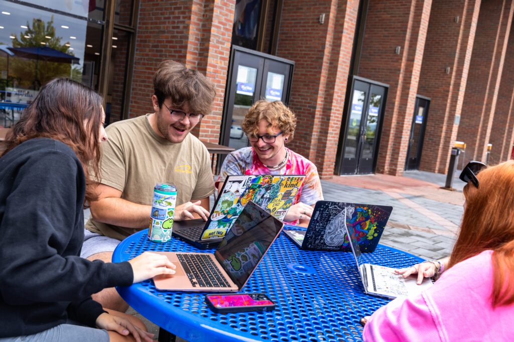 Student Orientation Leader Stock Photo Student Orientation Leaders sitting at a table and laughing on the College Union Patio.
