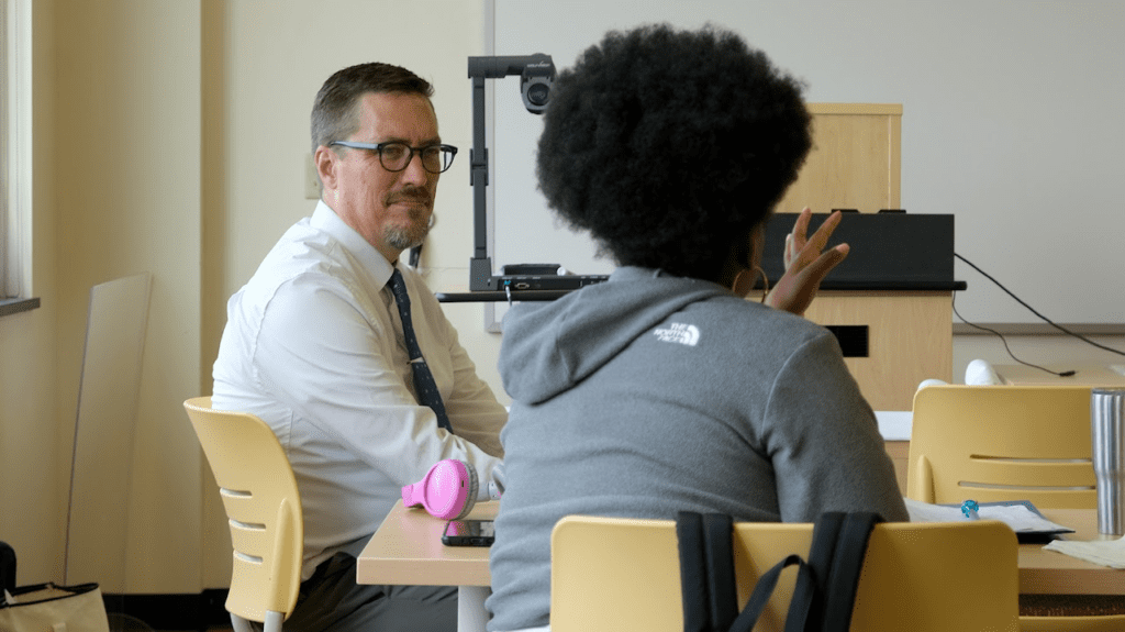 Two teachers talking to each other while seating
