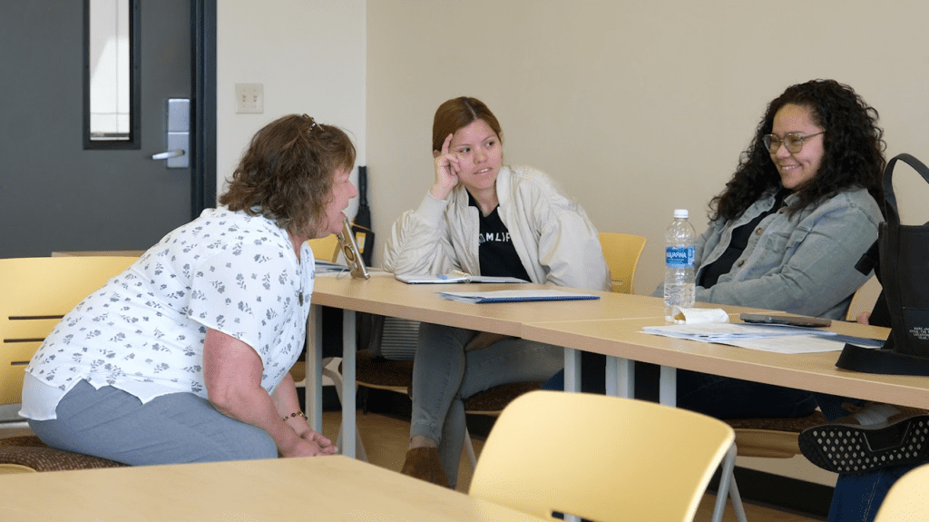 three women talking to each other while seating