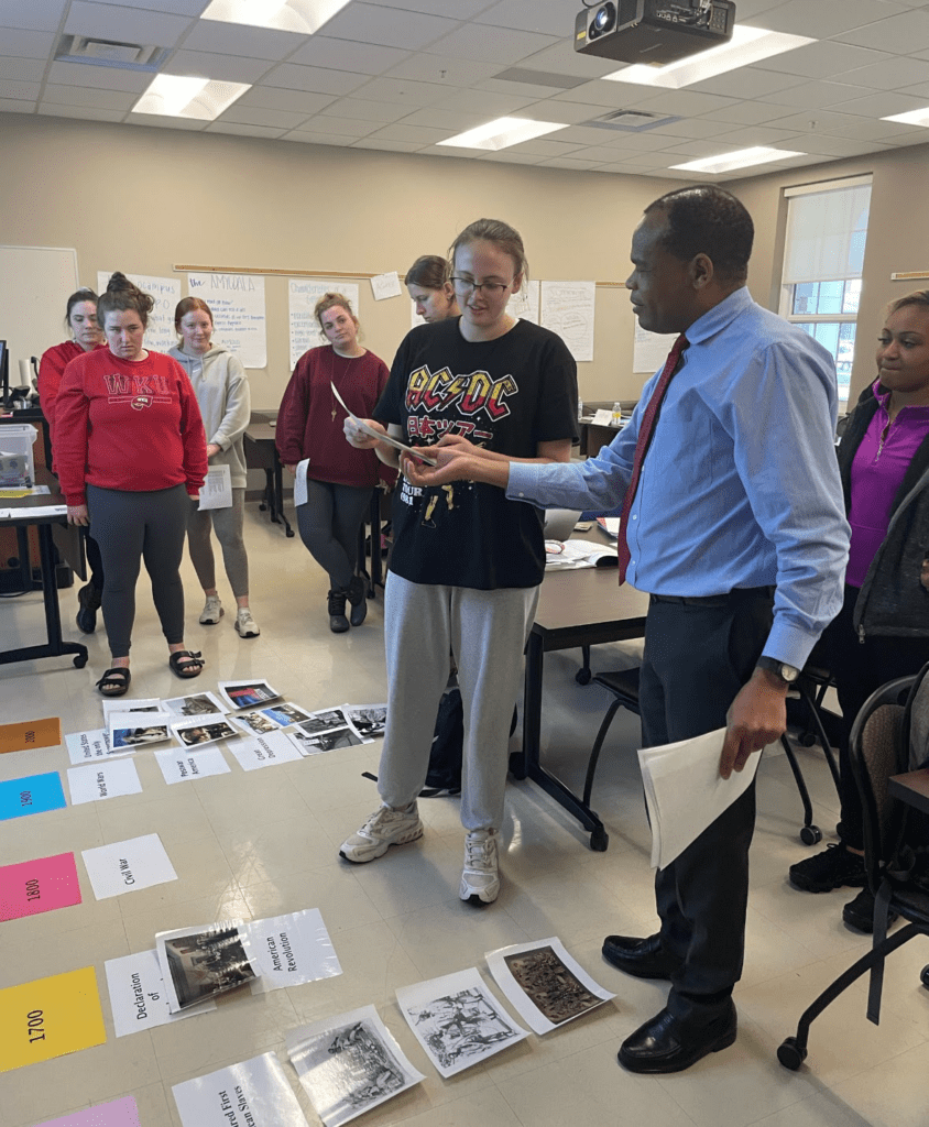 Student showing teacher something on a display card