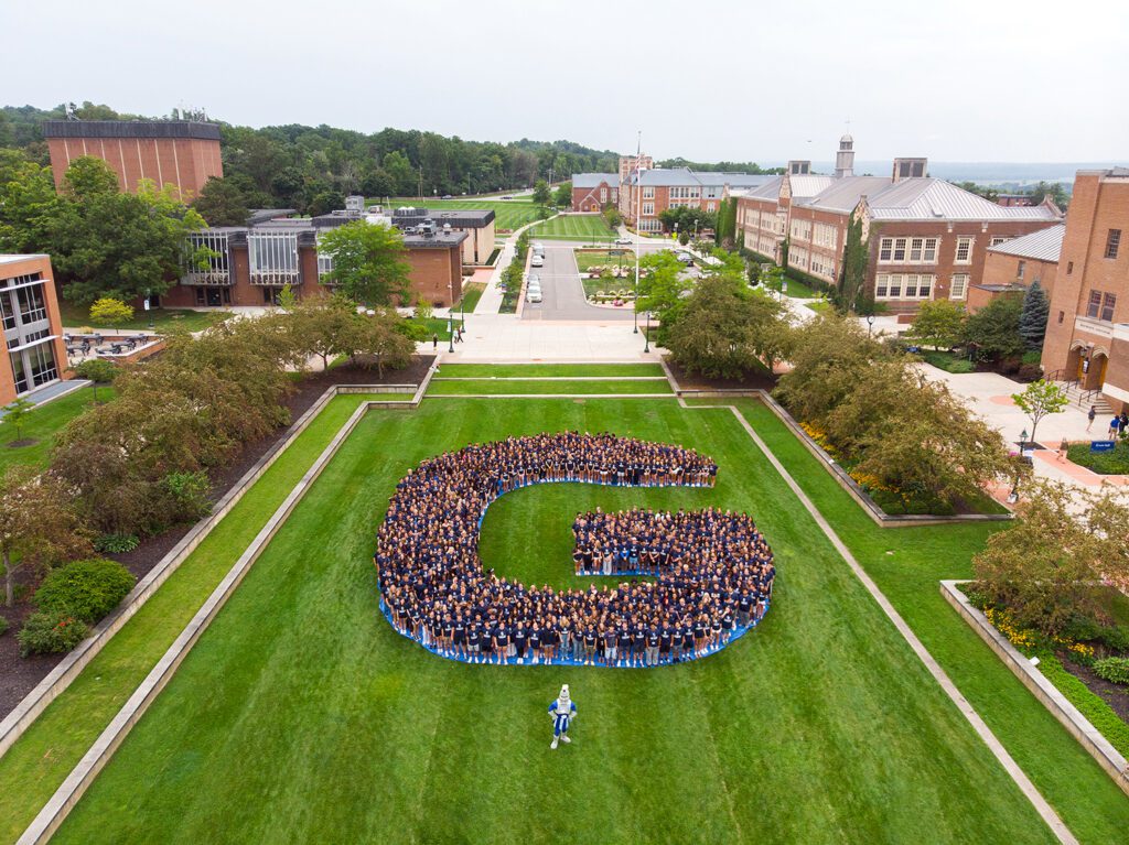 Students standing in a "G" shape