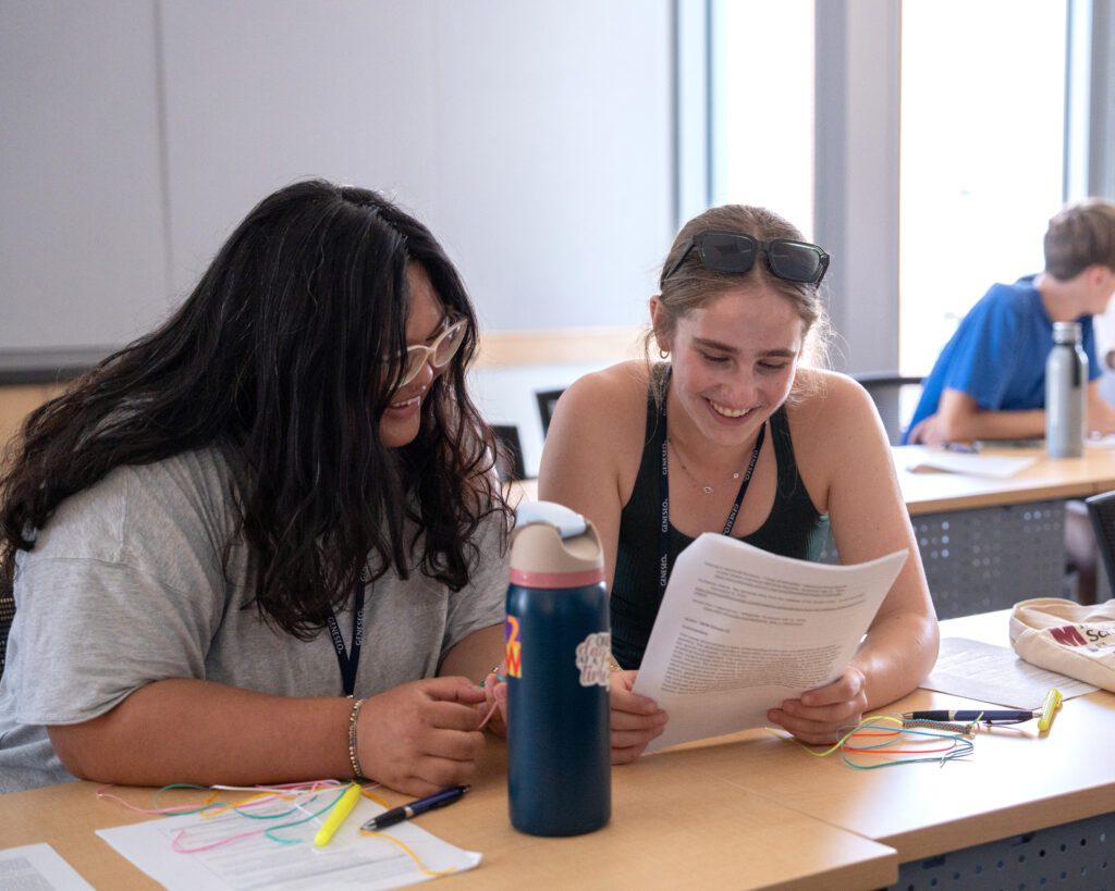 Two IB students looking over notes.