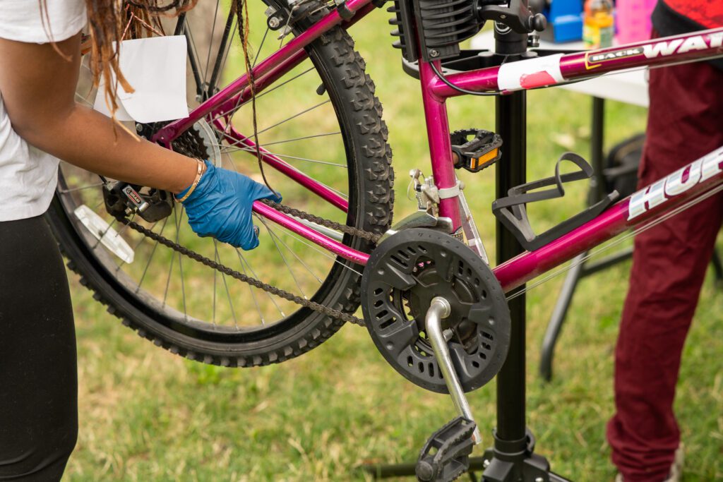 Photo of a person's hand on the frame of a bicycle.